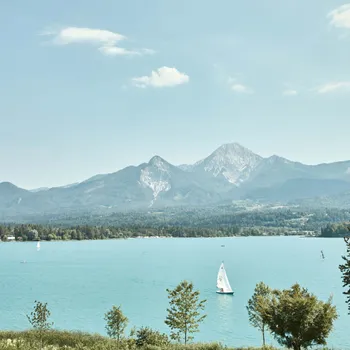 Detox-Tage am Faaker See Segelboot auf türkisfarbenem Alpensee vor bewaldeten Bergen
